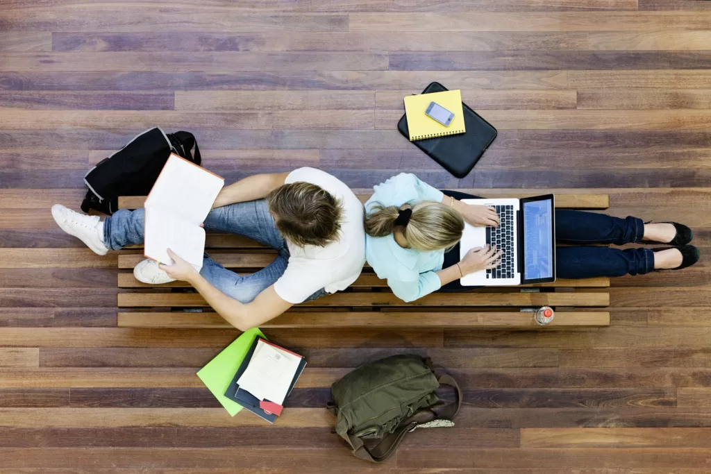 Two students sitting on the floor